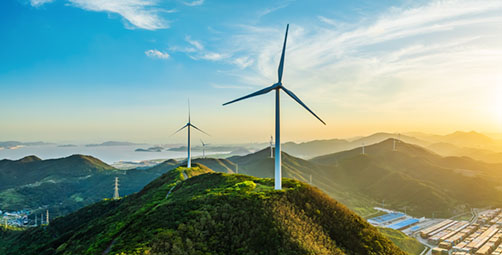 Wind turbines on a mountain during a sunrise.
