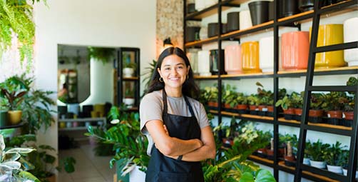 Female Business owner standing in front of her plant business.