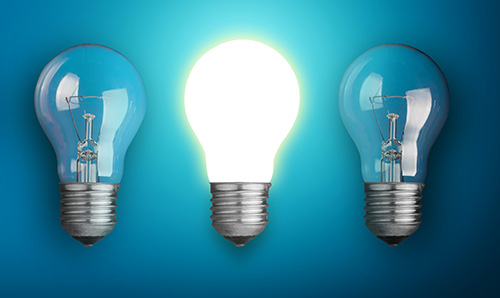 Dim light bulbs and one lit up representing an idea generated.