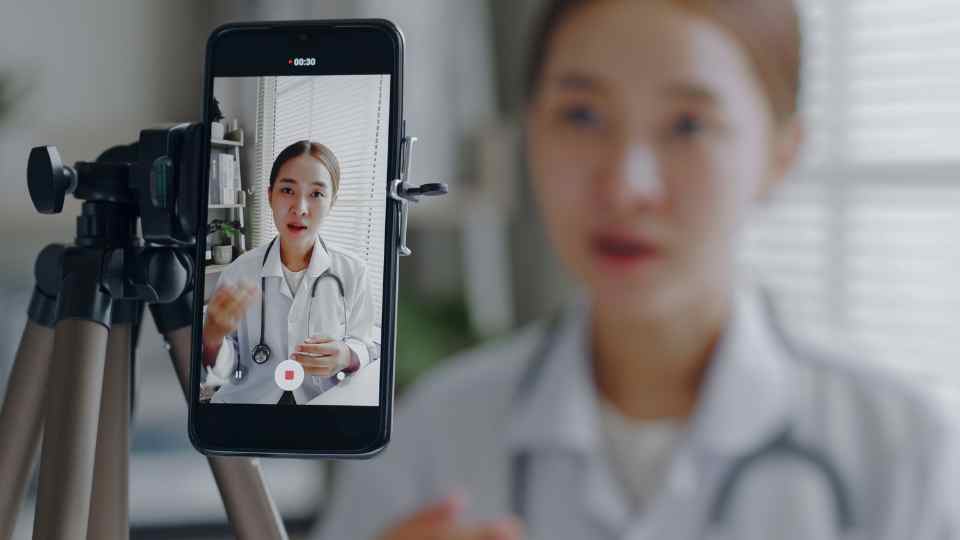 Doctor making online live streaming broadcast talking over camera recording in hospital, medical and healthcare blogger, vlogger concept