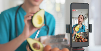 An individual dressed in scrubs is talking about food to a camera.