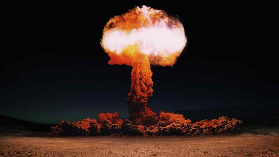 Terrible explosion of a nuclear bomb with a mushroom in the desert.