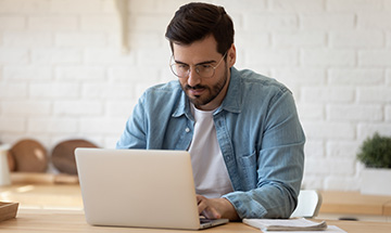 Man on computer filling in a form. 