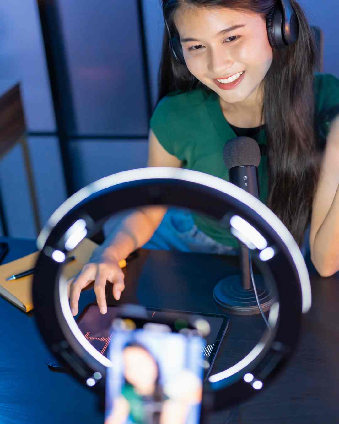 A social media influencer talking to the camera sat behind a large ring light.